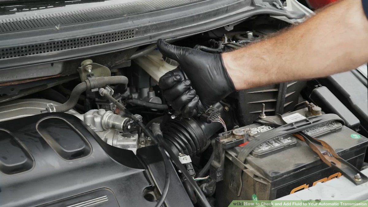 “Checking transmission fluid using a dipstick.”
