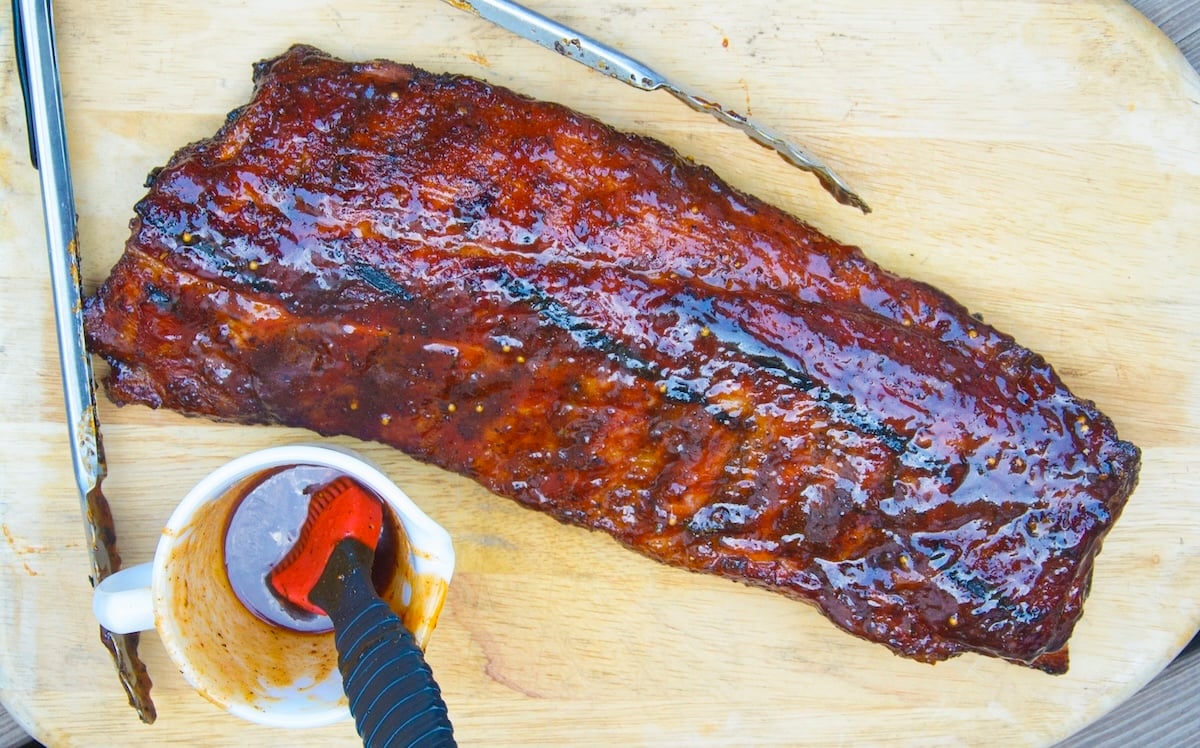 “Perfectly smoked BBQ ribs with glaze on wooden board.”